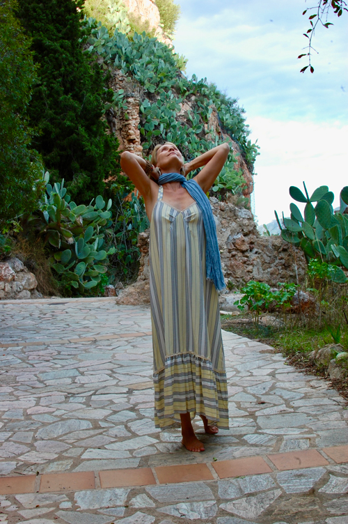 Woman in striped maxi dress with blue scarf in Mediterranean garden